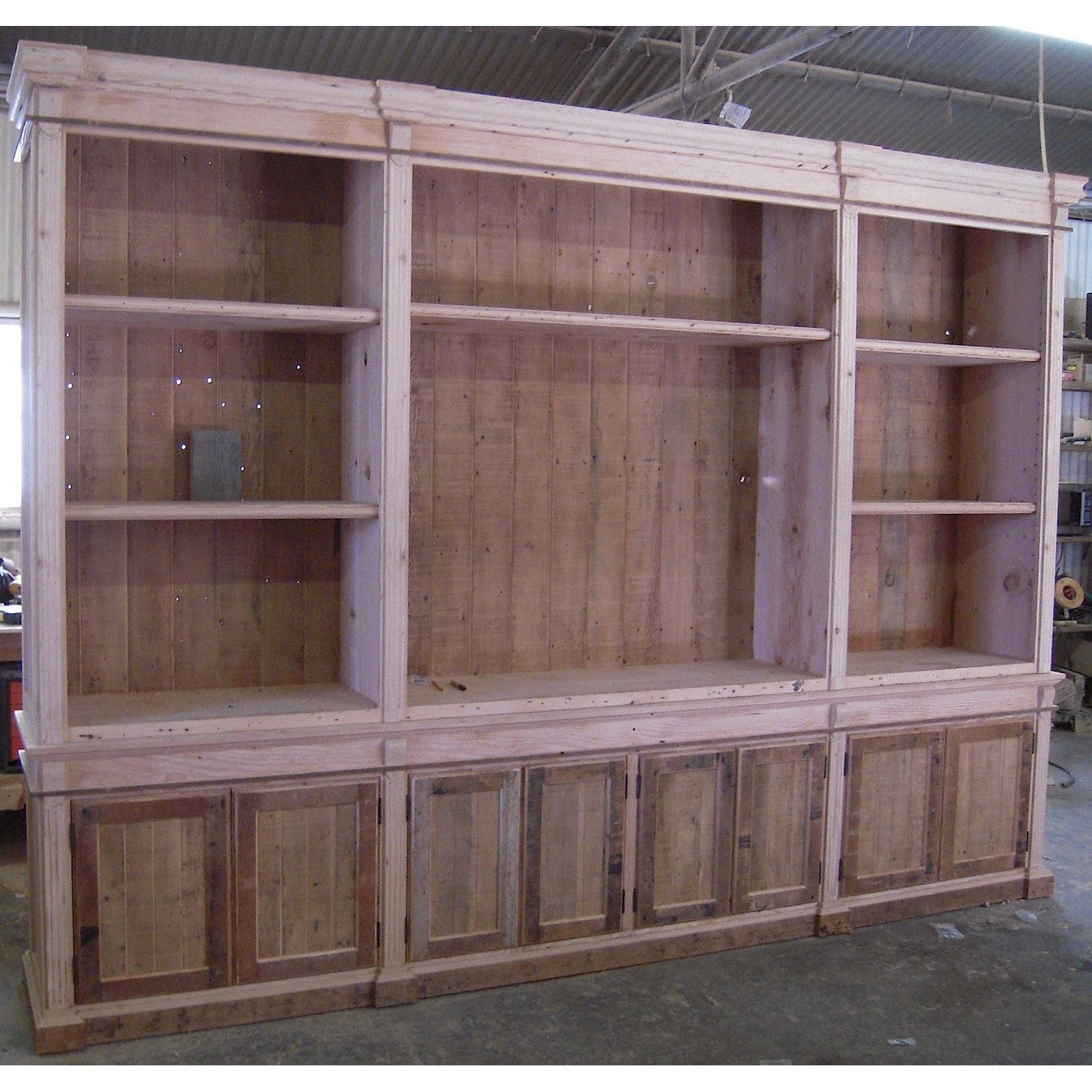 solid reclaimed wood builtin bookcase with bottom paneled cabinet doors