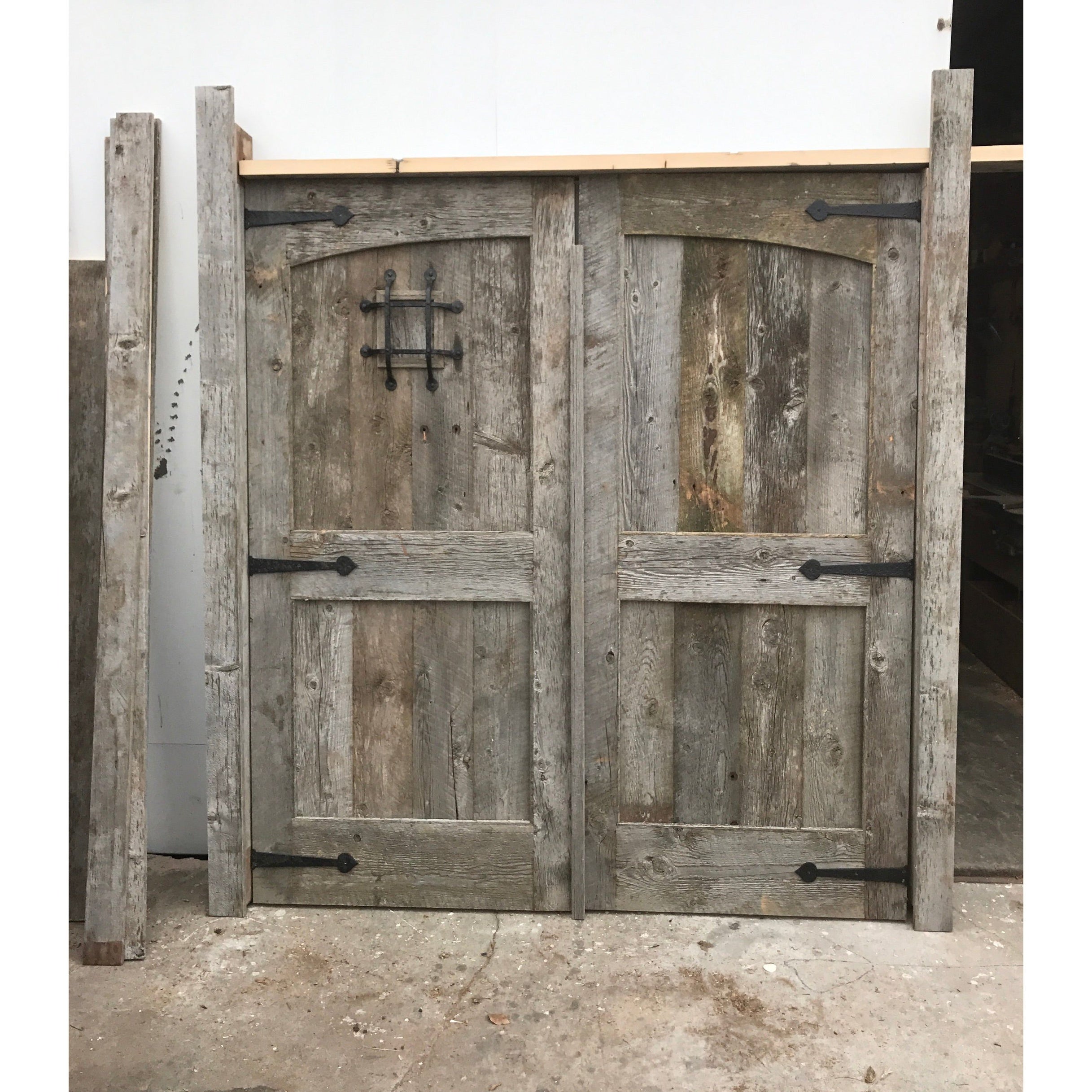 custom salvaged barn wood front doors with speak easy hardware 