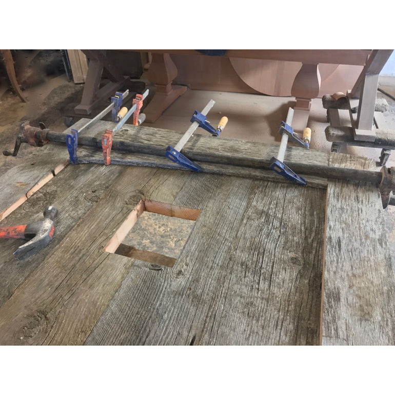 glueing up salvaged barn wood panels for a door 