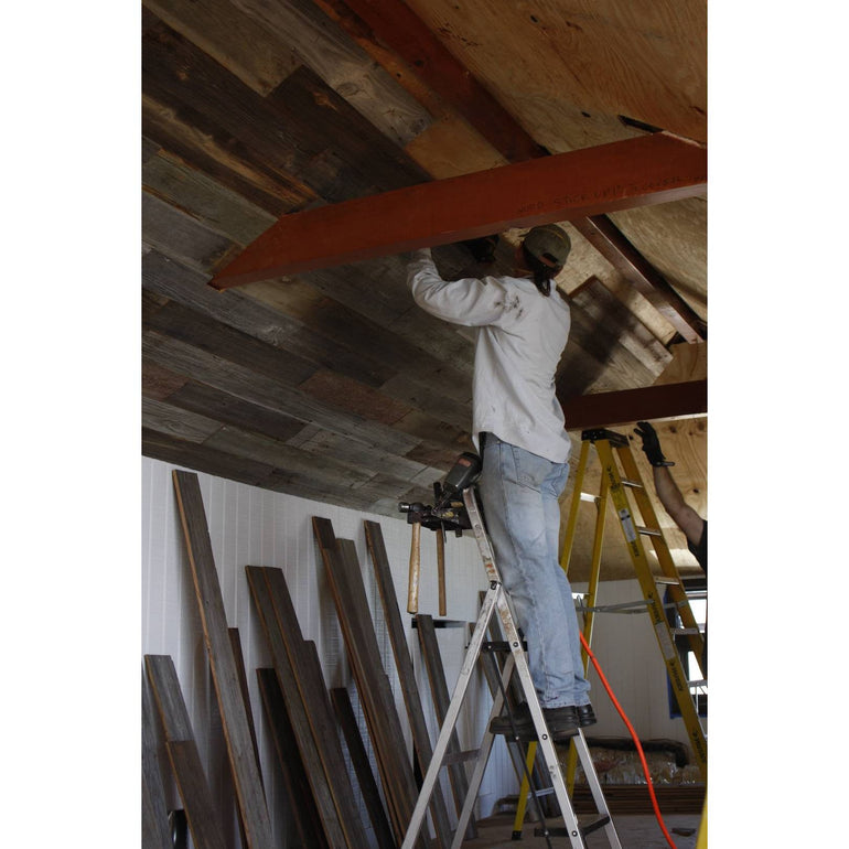 Installing Salvaged Barn Wood planks one the Ceiling of a home in Malibu
